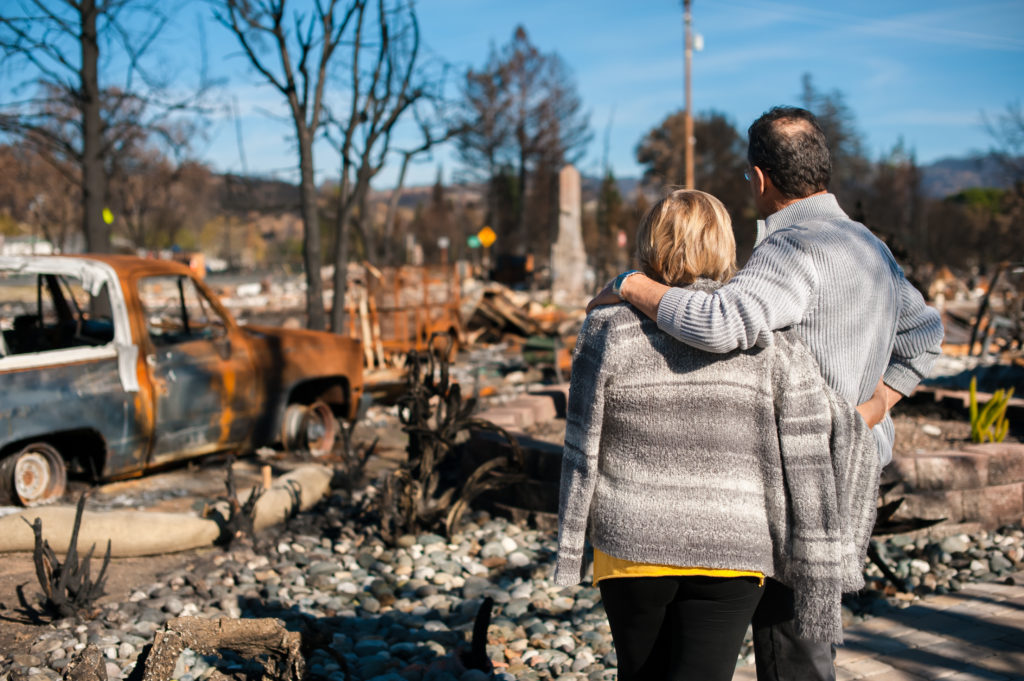 a couple looking at their destroyed property